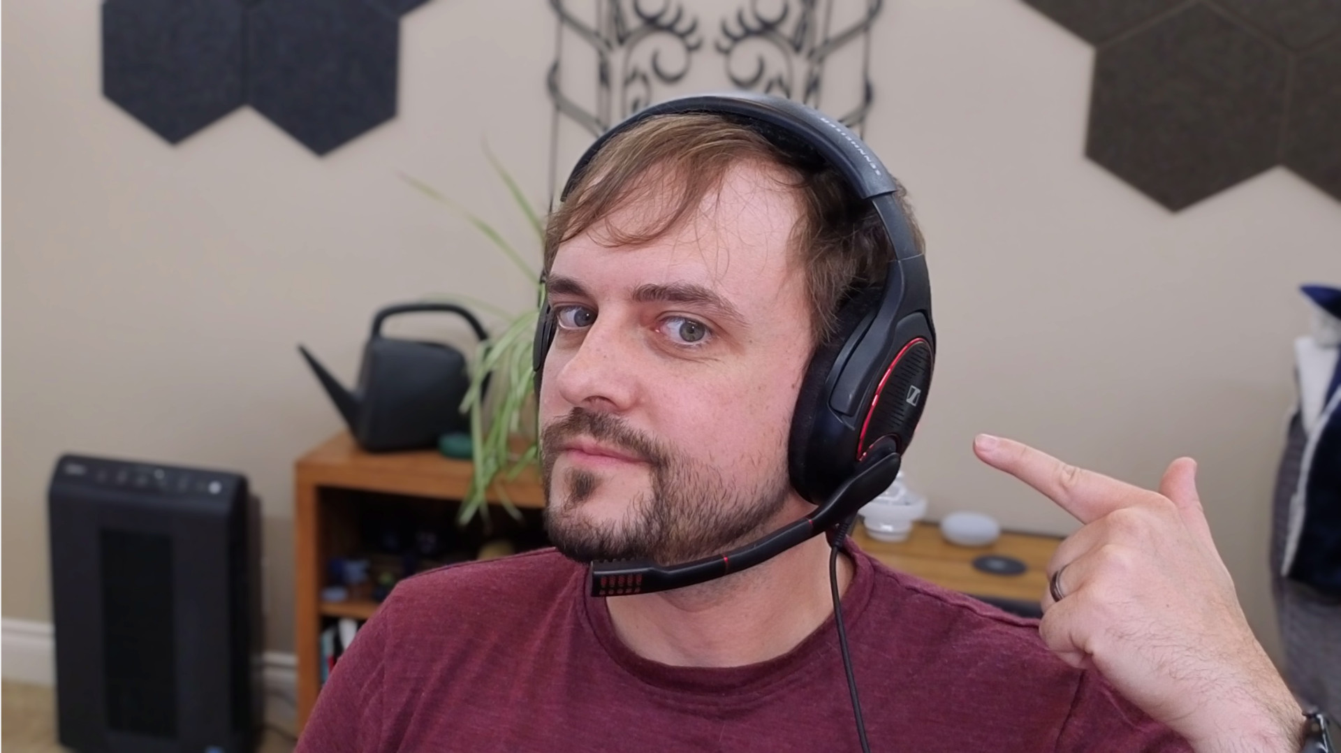 The author wearing a gaming headset and posing while pointing at the headset.